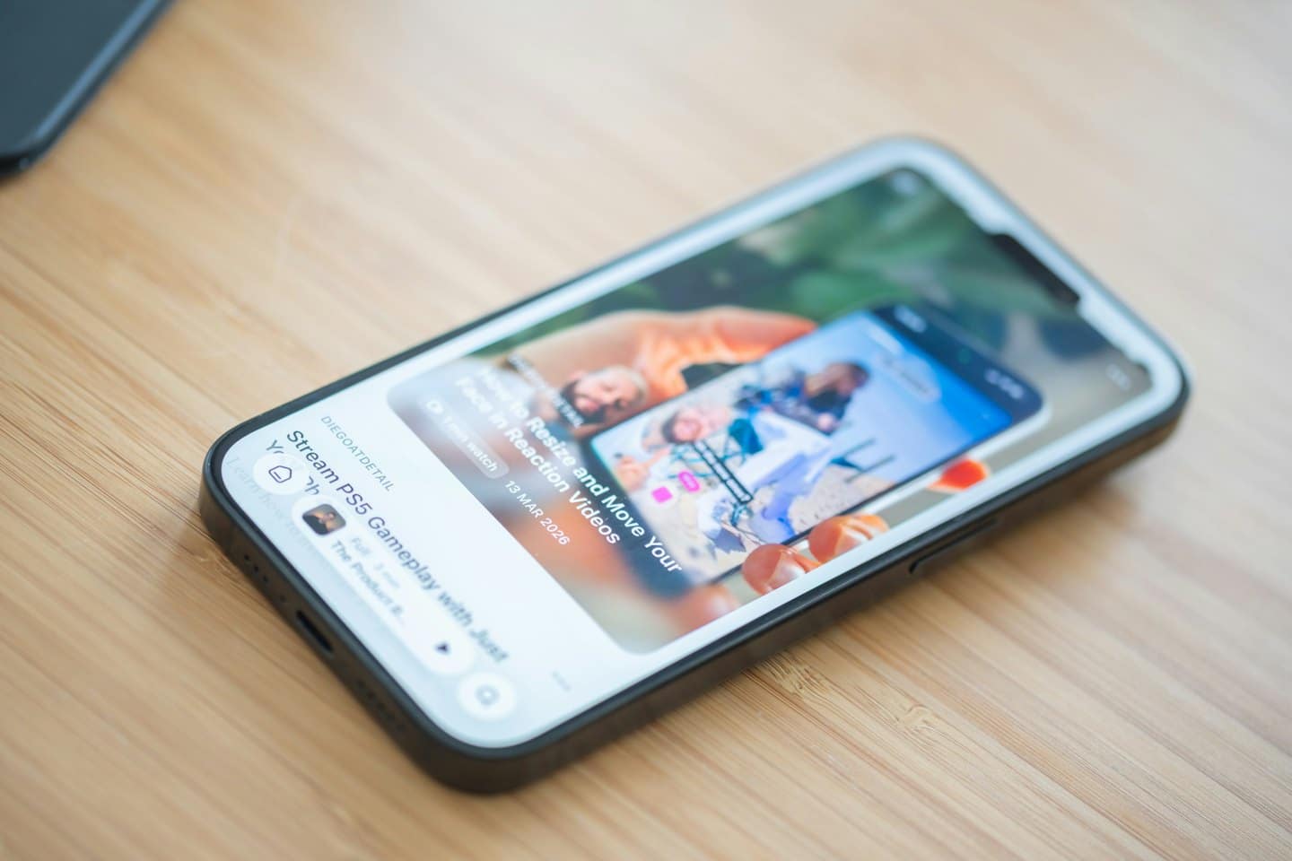 Schermo di uno smartphone che mostra un video tutorial su una superficie di legno.
